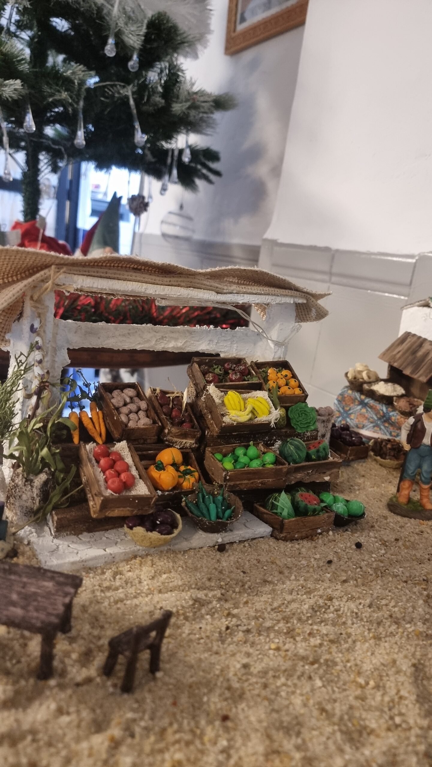 Puesto de fruta construido íntegramente a mano, con estructura de cartón y yeso, y cajas y frutas modeladas en arcilla.