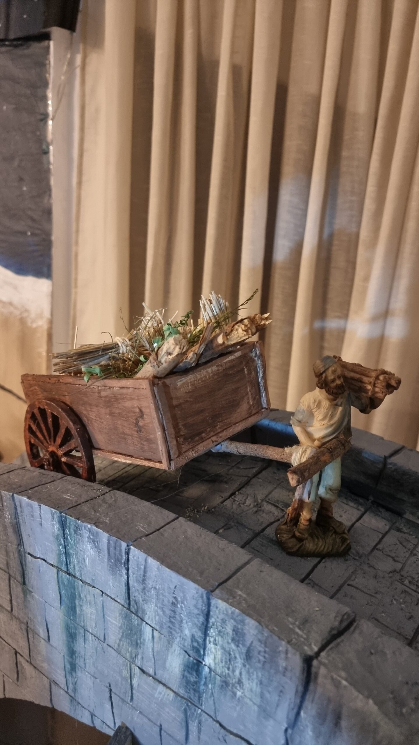 Carro hecho a mano con cartón y porexpán que cruza el puente, también construido artesanalmente en porexpán.