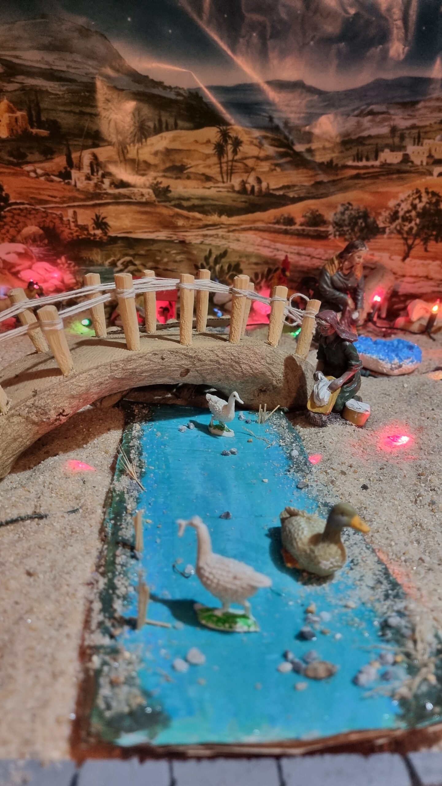 Río recreado con cartón y acrílico y puente de madera de olivo, integrados en una de las escenas del belén.