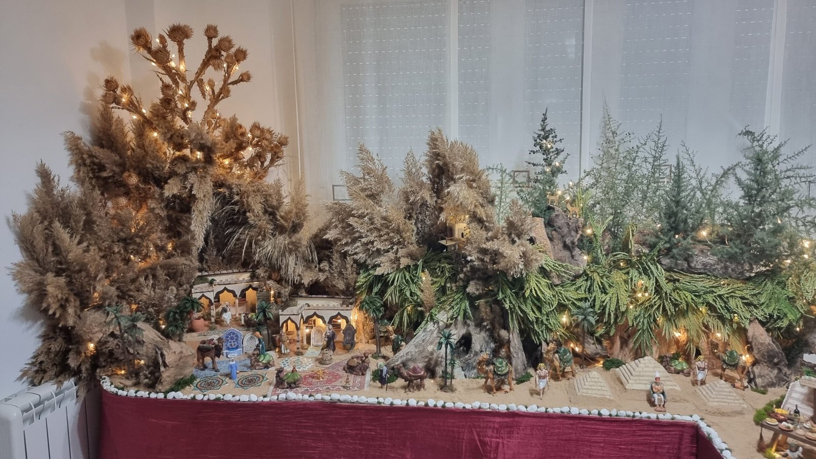 Detalle del belén donde conviven pirámides, arquitectura oriental y casas ambientadas con alfombras, reflejando la mezcla de culturas presente en el conjunto.