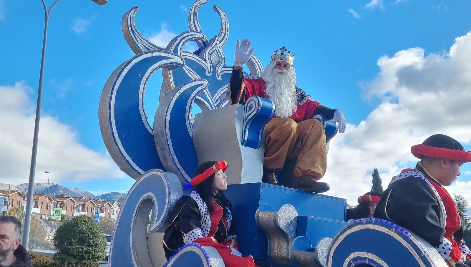 Melchor saluda con cercanía y emoción desde su carroza, repartiendo ilusión entre pequeños y mayores durante su paso por las calles de Peligros.