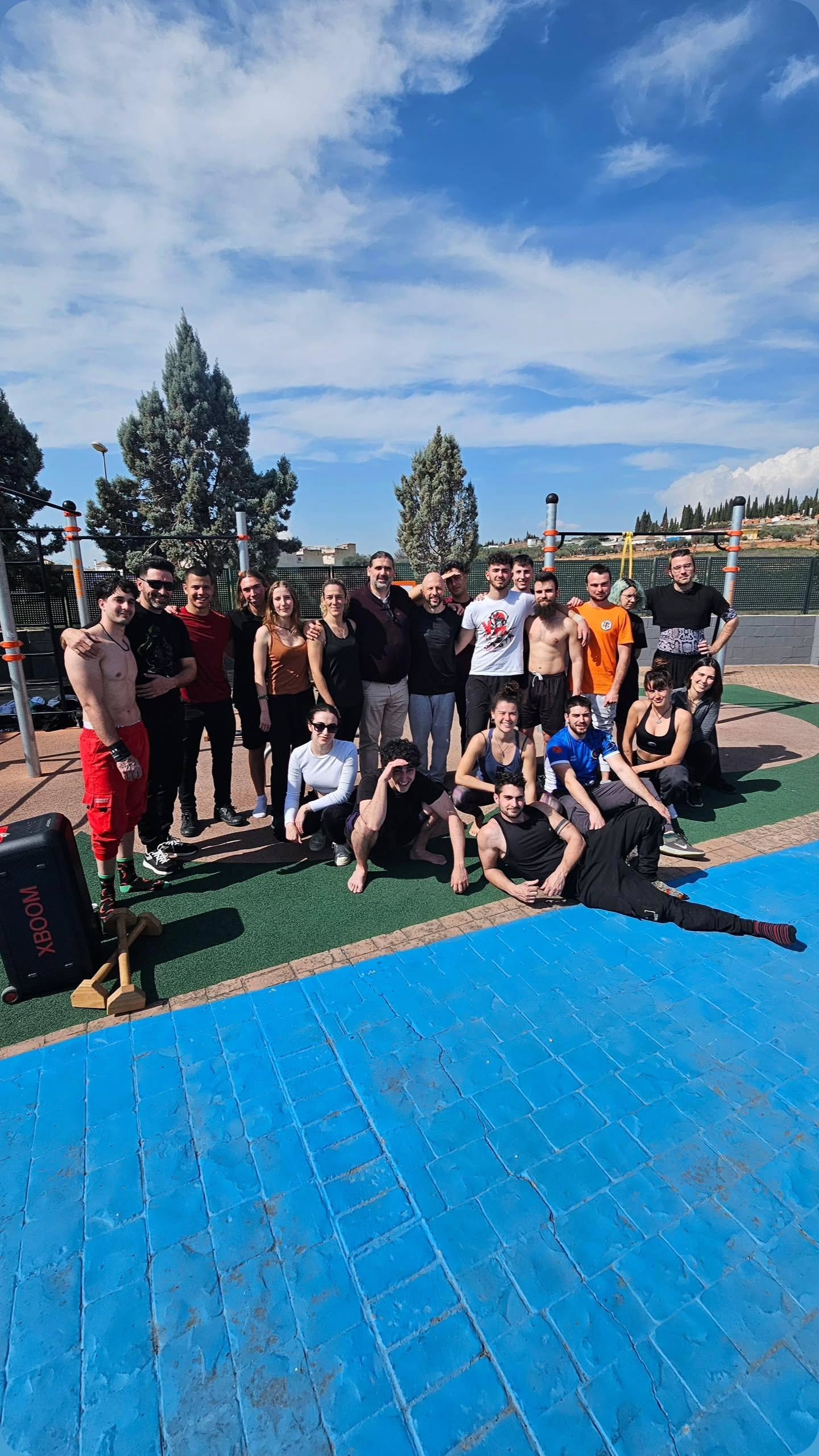 Participantes en actividad de entrenamiento al aire libre en la zona de calistenia del recinto deportivo.