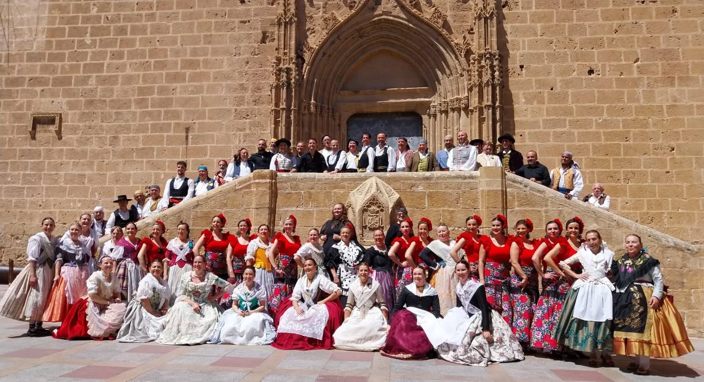 Foto de familia de la Compañía Folclórica CYD de Peligros y el Grup de Danses Portitxol de Xàbia en las escalinatas de la iglesia, tras el encuentro de danzas tradicionales celebrado en la localidad alicantina.